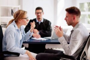 Young couple arguing in front of male judge, contemplating divorce