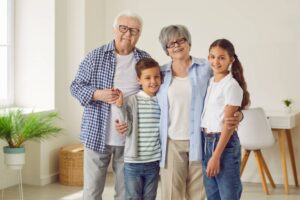 Group portrait of happy grandparents together with children. Kids at grandparents' house