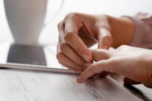 woman hands removing a ring from their finger with a document on the table